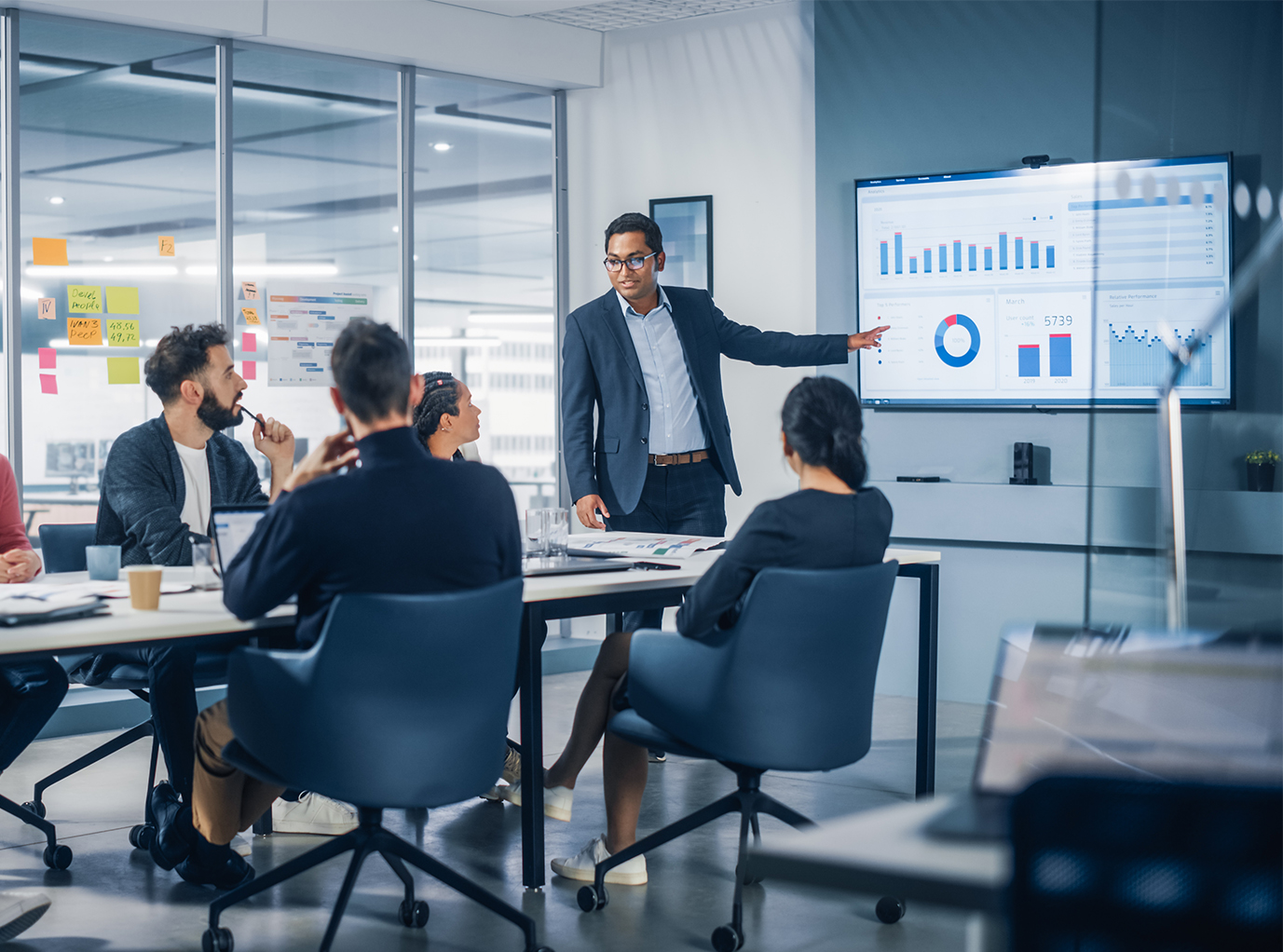An executive displays dealership profitability and operational metrics to board members, showcasing Readywire’s impact on business transparency and success.