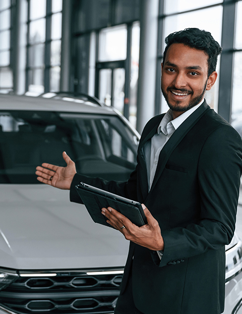 The image shows an employee of an auto dealership, symbolising the ERP solution for Auto Dealerships by Readywire.